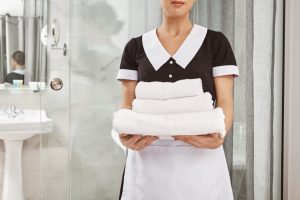 Everything is fresh and clean. Cropped portrait of housecleaner in maid uniform holding pack of white towels. Employee brought everything customer ordered to his hotel room