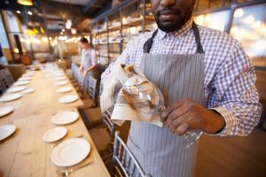 Waiter Cleaning Crystal Glasses for Banquet