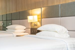 White comfortable pillow and blanket on bed with light lamp